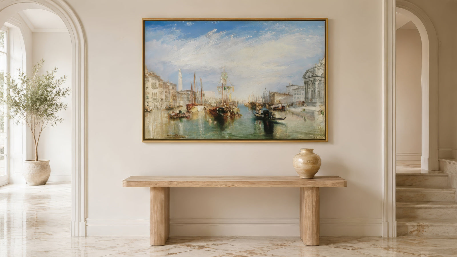 Impressionist Venice Grand Canal painting in coastal blue and ochre, gold-framed above a wood console in a sunlit Mediterranean living room.