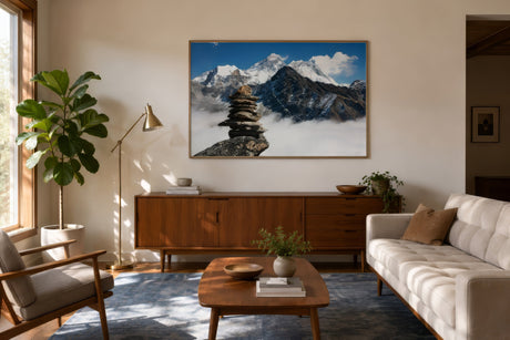 Asian-style mountain landscape print of a stone cairn above misted Himalayan peaks, framed in a warm mid-century living room.