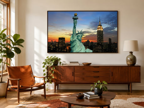 Color New York print of the Statue of Liberty and skyline at sunset, framed above a walnut credenza in a mid-century living room.