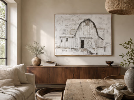 Rustic barn landscape canvas in ivory and grey, framed in light wood above a reclaimed wood sideboard in a warm dining room.