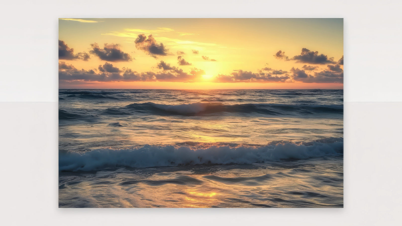 Golden-hour beach sunset canvas of ocean waves in amber and blue, framed above a linen sofa in a bright coastal living room.