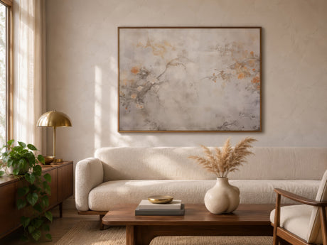 Framed vintage sepia bird print in grey and amber hung above a boucle sofa in a neutral, sunlit living room.