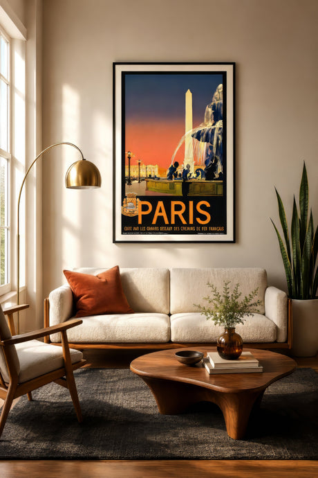 Vintage Paris travel poster with the Concorde obelisk and fountain in orange and black, framed above a cream sofa in a warm living room.