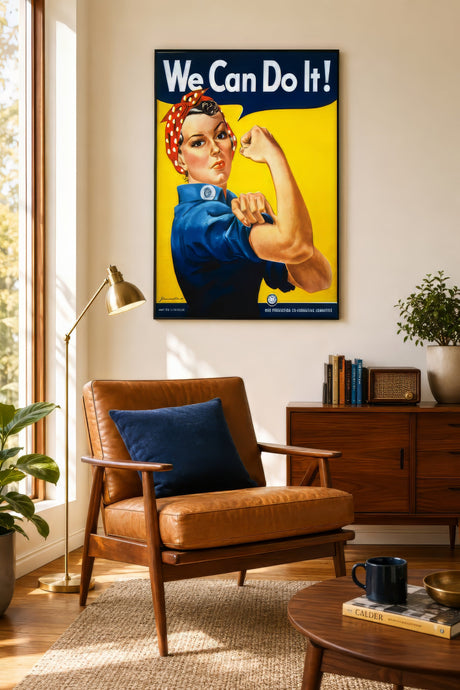 Vintage We Can Do It Rosie the Riveter poster in blue, red, and yellow, framed above a leather chair in a warm home office.
