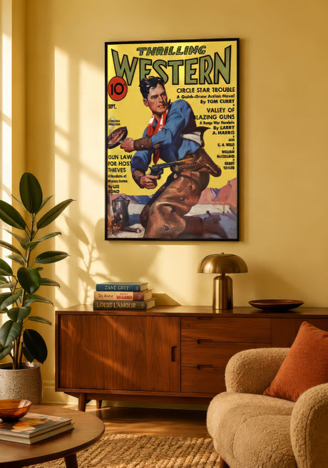 Framed Thrilling Western pulp magazine cover with cowboy illustration in blue and yellow above a mid-century walnut console in a sunny living room.