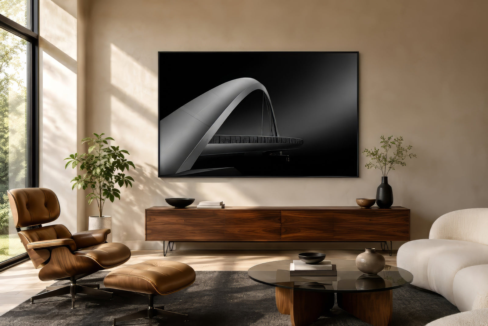 Architectural abstract canvas of an arched bridge in high-contrast black and silver, framed above a sofa in a modern living room.
