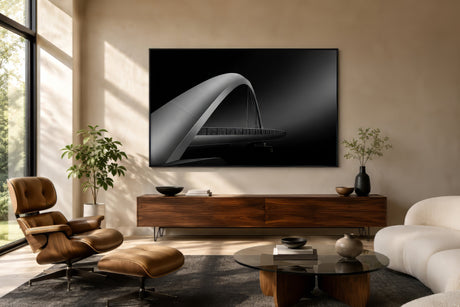 Architectural abstract canvas of an arched bridge in high-contrast black and silver, framed above a sofa in a modern living room.