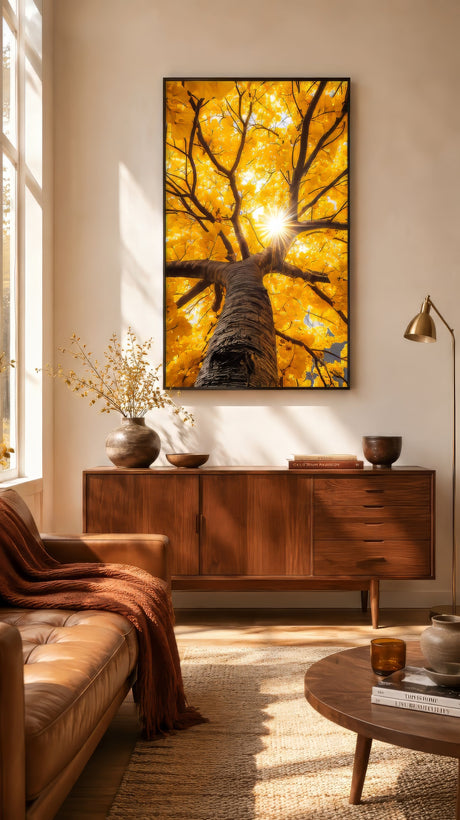 Golden upward-view tree canvas in amber and yellow tones, framed in black above a walnut sideboard in a warm nature-inspired living room.