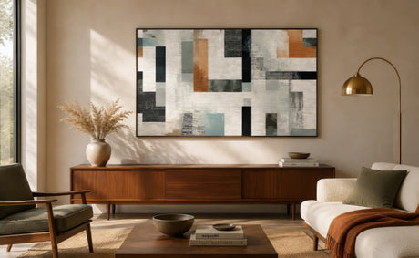 Modern abstract geometric art print in rust, slate blue, black and ivory, framed above mid-century console in warm living room.