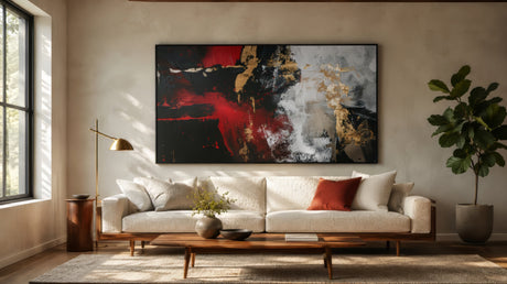 Red, black, and gold abstract canvas above a white boucle sofa, modern living room focal point with warm neutral tones.