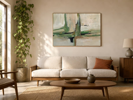 Sage green and cream abstract wall art in oak frame above linen sofa in warm, sunlit living room.