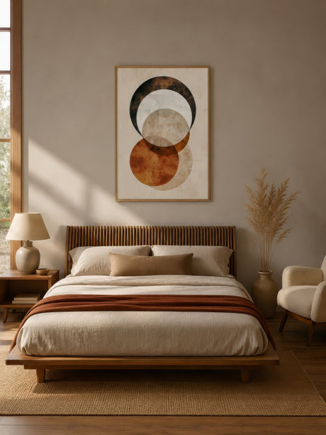 Abstract earthy circle art in beige, brown, and rust, framed above a wooden bed in a warm cozy bedroom.