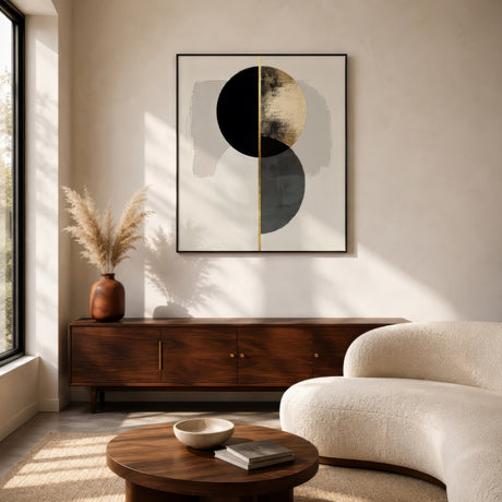 Black and gold abstract circle canvas in slim frame above a wood sideboard in a minimalist living room.