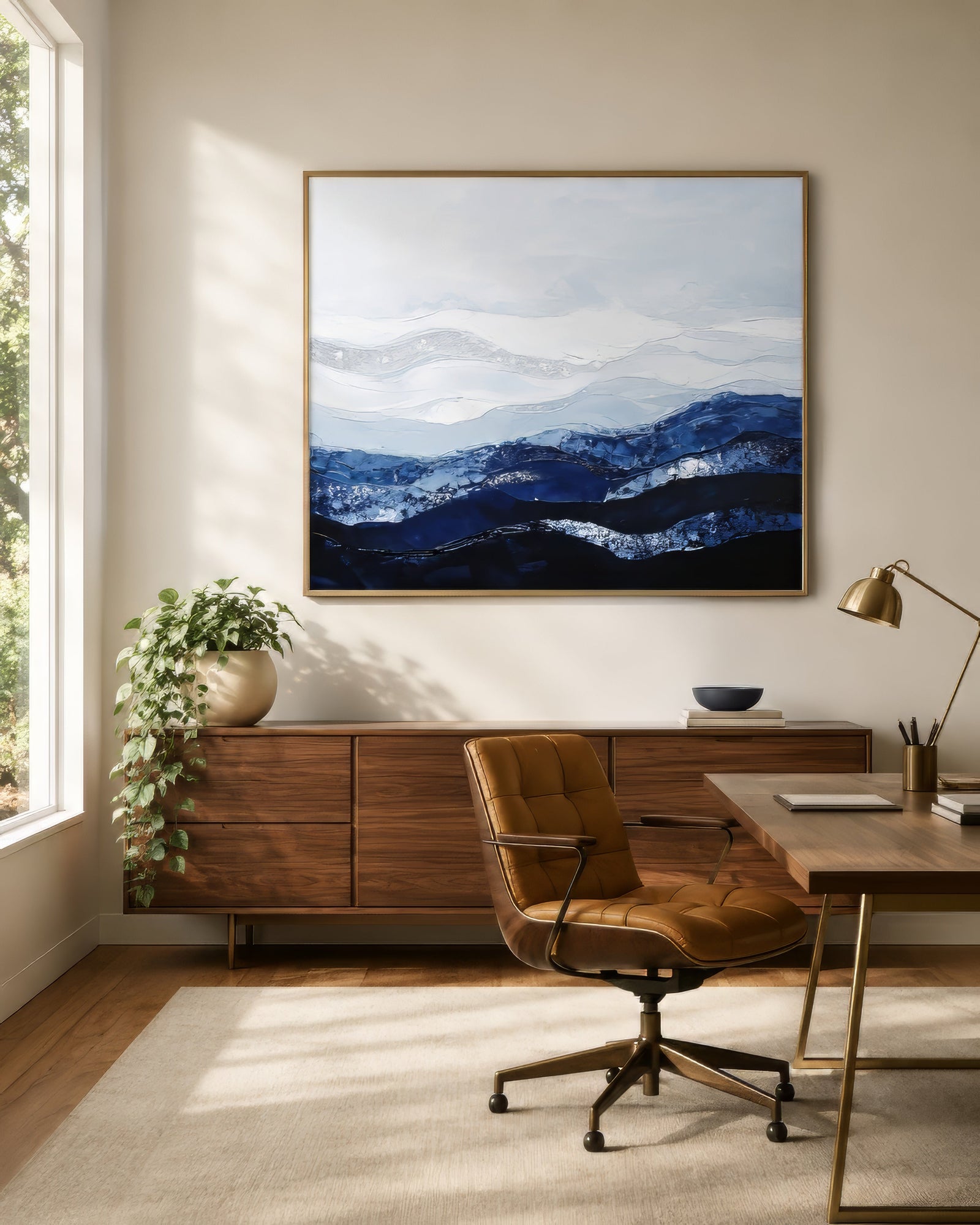 Minimalist misty mountain landscape canvas in indigo and gray, framed above a wooden credenza in a serene home office.