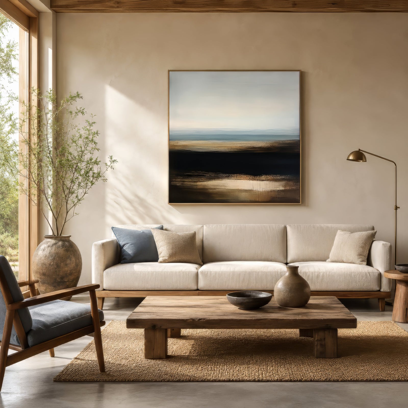 Abstract farmhouse landscape print in gold, black, and blue, framed above a linen sofa in a modern rustic living room.