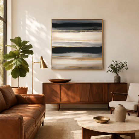 Beige and gold textured abstract canvas with horizontal relief bands, framed above a wood credenza in a warm mid-century living room.