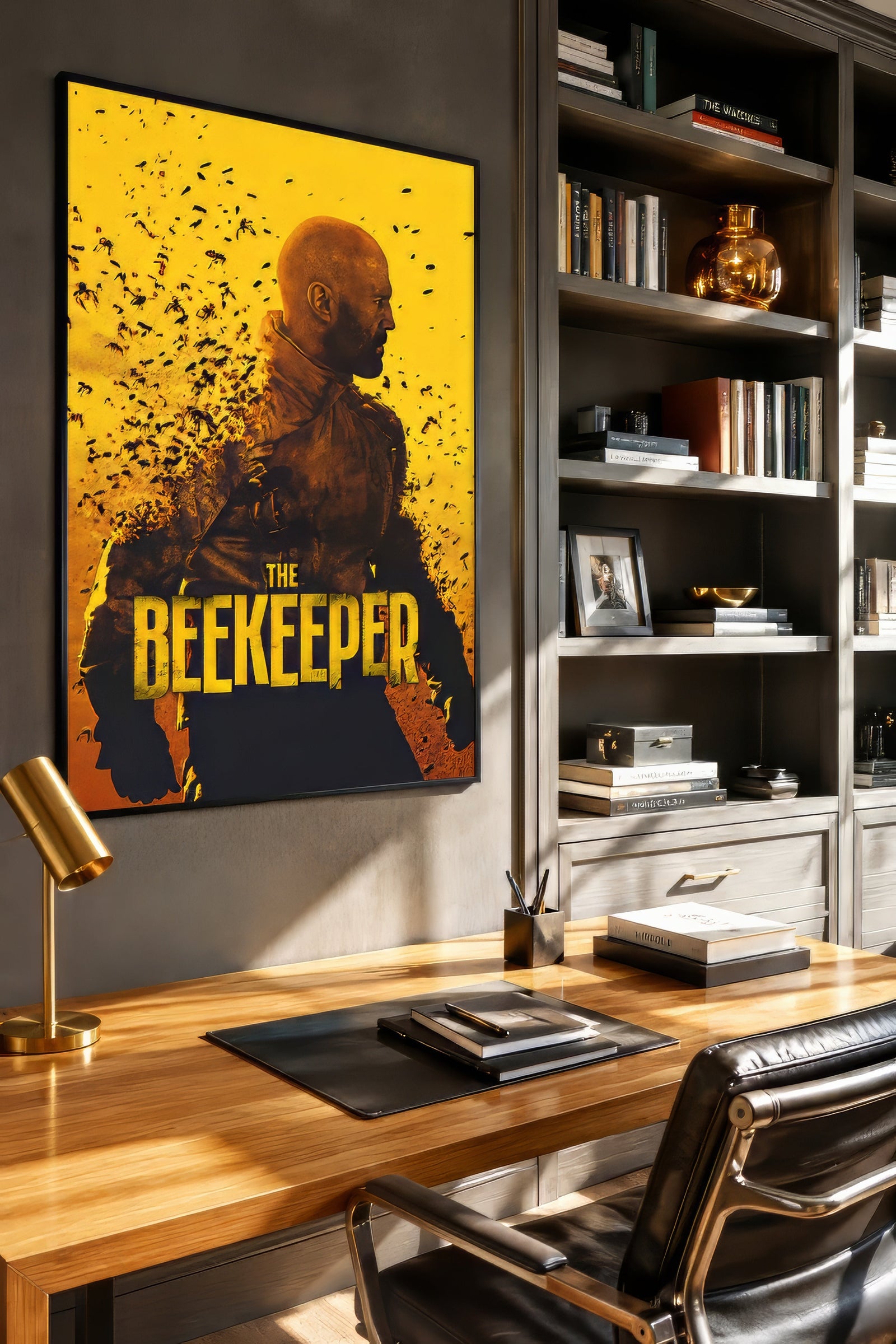 The Beekeeper vintage film poster in bold yellow, black, and amber, framed above a wooden desk in a moody home office.