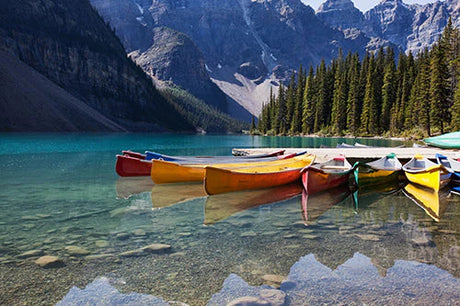 Alberta Collection wall art featuring a canoe on a serene lake amidst majestic mountain ranges