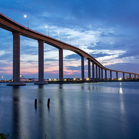Chesapeake Bay Bridge at twilight with city lights and calm water reflections – coastal architecture wall art for nautical home or elegant office décor.