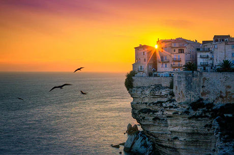 Corsica Collection wall art featuring a sunrise over a rocky coastal terrain with blue ocean horizon