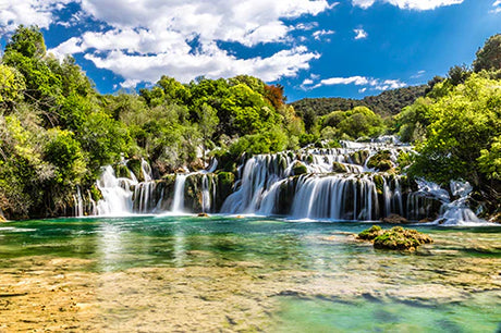 Croatian natural landscape wall art featuring a vibrant green vegetation, waterfall, and serene stream.
