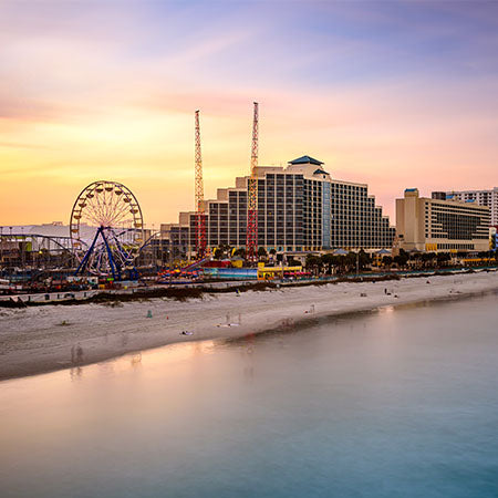 Daytona Beach boardwalk at sunset with hotels, ferris wheel, and calm shoreline – vibrant coastal wall art for modern beach house or office décor.