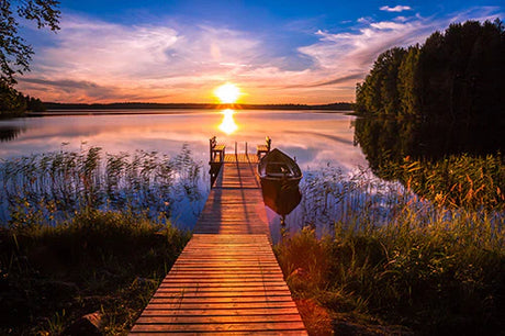 Summer sunset over a Finnish lake with natural landscape and afterglow horizon