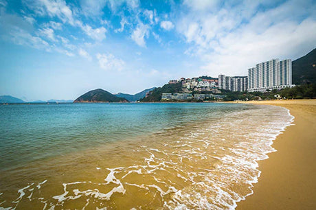 Hong Kong cityscape wall art featuring high-rise condos, sandy beach, and oceanic bay view