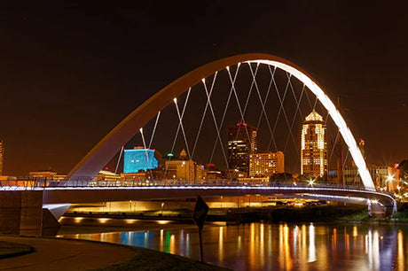 Night view of iconic cable-stayed arch bridge in metropolitan Iowa, landmark city architecture