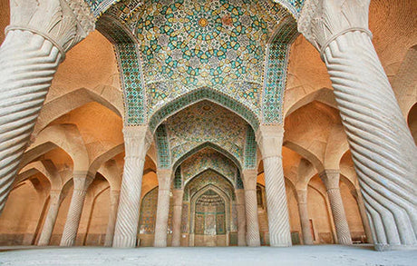 Ancient Iranian architecture with symmetrical arches and columns, ceiling details at a historic tourist site
