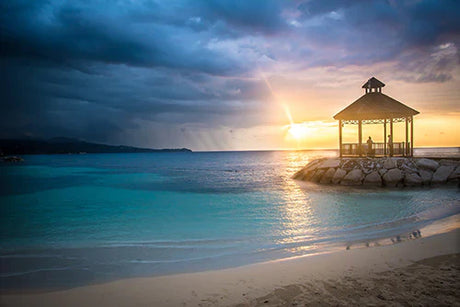 Stunning Jamaican beach wall art featuring a serene blue sea, summer clouds, and coastal landforms.