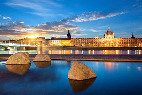 Dusk over Lyon cityscape with notable landmarks reflected on blue water, evening tourist attraction
