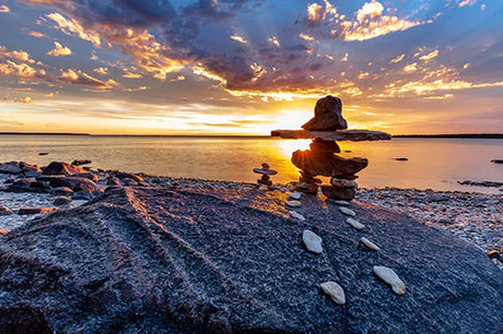 Sunset reflection on water with rocks during dusk in Manitoba wall art collection