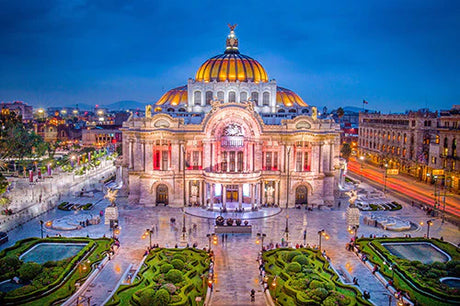 Night view of Byzantine and classical architecture in Mexico City featuring a dome, palace, and finial landmark