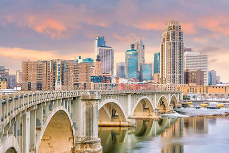 Daytime view of Minneapolis city, showcasing the arch bridge, skyscrapers, and waterway