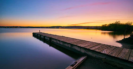 Stunning Minnesota sunset over a serene body of water with a pier at dusk