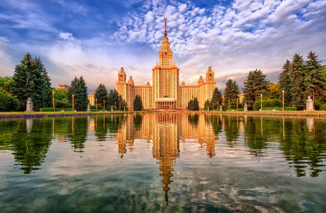 Evening view of Moscow landmarks reflected in a channel, featuring towers, spires, and finials
