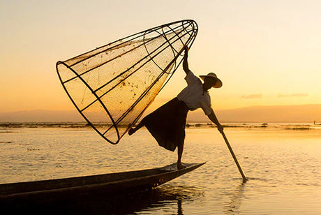 Myanmar collection wall art featuring a fisherman on a boat at dusk, surrounded by nature