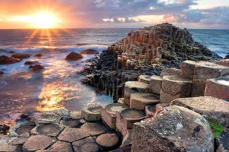 Dutch coastal sunset wall art featuring rocky shoreline, oceanic landforms, and dramatic dusk clouds