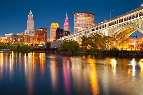 High-rise buildings along a waterway in urban Ohio, featuring a bridge and metropolitan skyline.