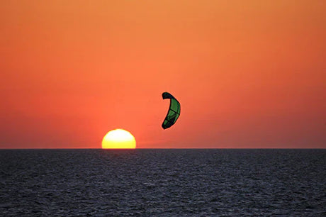 Outer Banks wall art featuring kite sports at dusk with orange sunset over fluid sea horizon