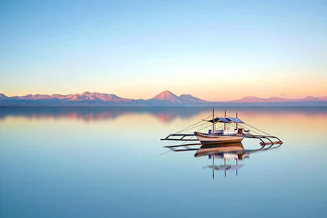 Morning view of a boat on a serene blue lake with oceanic landforms in the Philippines