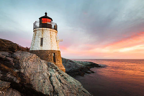 Dusk view of Rhodes lighthouse on rocky coast, beacon tower overlooking sea horizon
