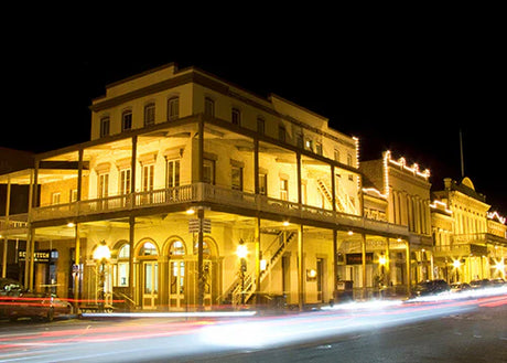 Sacramento night scene wall art featuring mixed-use architecture, luxury vehicles, and illuminated columns.