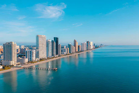 Daytime view of San Diego high-rise buildings by the blue sea under cloudy sky