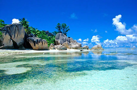 Seychelles collection wall art featuring blue ocean, cloudy sky, and sandy beach landscape