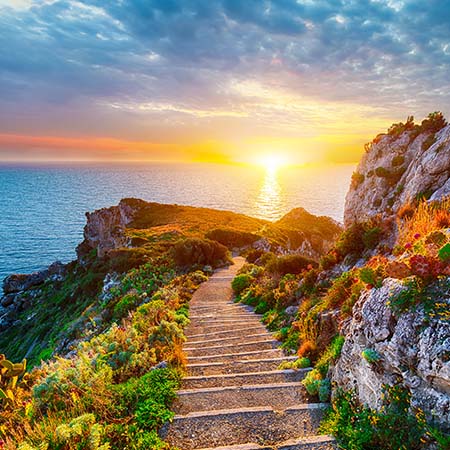 Scenic coastal path in Sicily at sunset with ocean views, cliffs, and wildflowers – Mediterranean wall art for serene home or office décor.