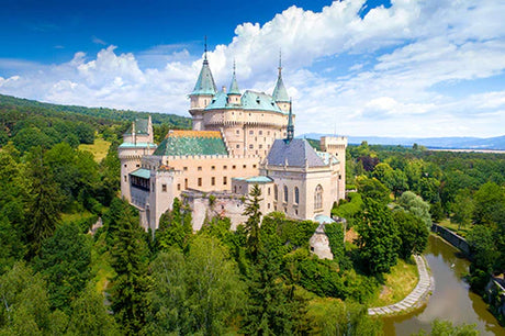 Medieval water castle with a turret and spire in Slovenia, a popular tourist attraction
