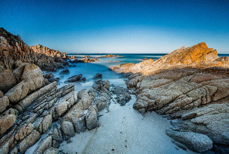 Blue coastal wall art featuring Tasmanian rock formations and wilderness terrain