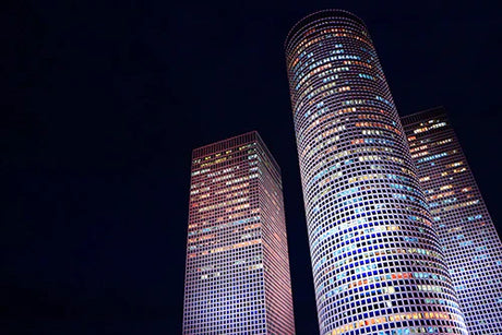 Nighttime view of metropolitan Tel Aviv with skyscrapers and landmark commercial buildings